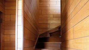 A wooden staircase with a wooden floor and walls, leading to an upper level. - Gray house toya (Toyako)