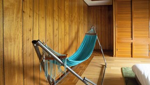 A hammock in a room with wooden walls and a bed. - Gray house toya (Toyako)