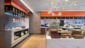 Una cocina moderna con encimera de mármol, diversos alimentos a la vista y una persona de pie junto a la encimera.