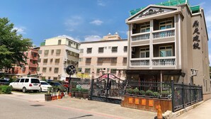 A multi-story building with balconies and a gated entrance. - Feng Ming home stay (Jinning)