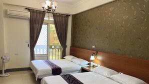 A hotel room with two beds, a ceiling fan, an air conditioner, a nightstand with a lamp, and a view of the outside balcony. - Feng Ming home stay (Jinning)