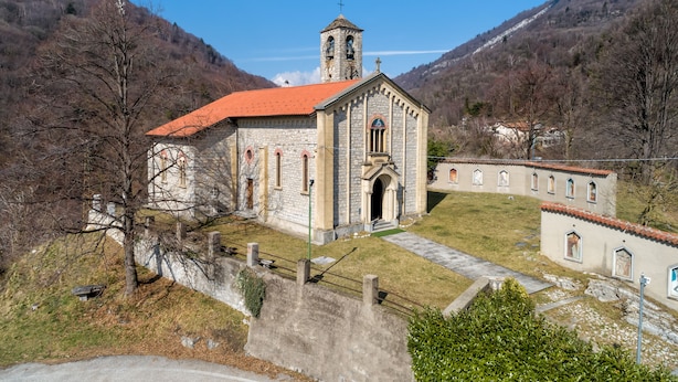 A stone church with a bell tower and a red roof, surrounded by mountains and a small building with arched windows. - Viola Apartment Lake Maggiore Retreat w/ Private Garden & Parking, Casalzuigno, Italy (Casalzuigno)