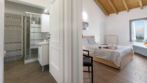 A bedroom with a bed, bedside table, and a window. - Viola Apartment Lake Maggiore Retreat w/ Private Garden & Parking, Casalzuigno, Italy (Casalzuigno)