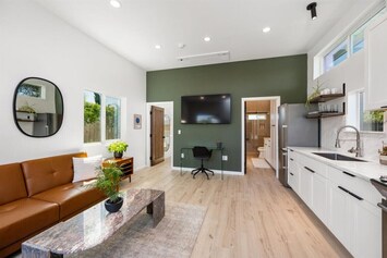 Open concept living area with fully stocked kitchen, smart TV & desk