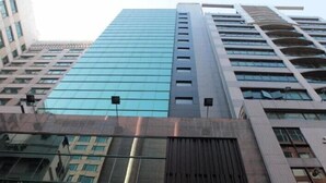Ένα σύγχρονο πολυώροφο κτίριο με γυάλινη πρόσοψη και ένα μείγμα αρχιτεκτονικών στυλ.