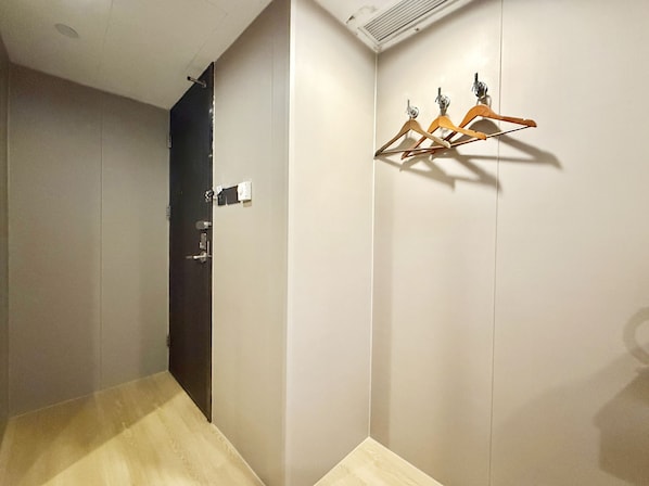A room with a wooden floor, a door, and a wall-mounted air conditioning unit. - Noble Park Hotel (Kowloon)