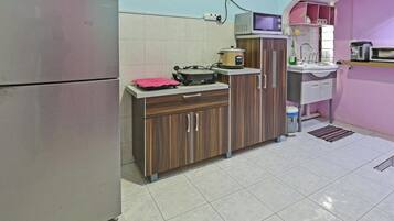 A compact kitchen with a refrigerator, microwave, stove, and sink.