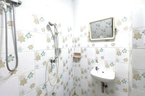 Une salle de bain avec une douche, un lavabo et un miroir.