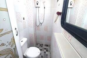 Een badkamer met toilet, douche en wastafel.