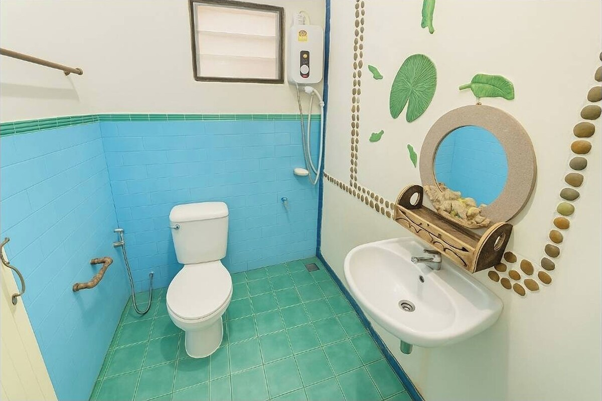A bathroom with a toilet, sink, and a wall-mounted mirror.
