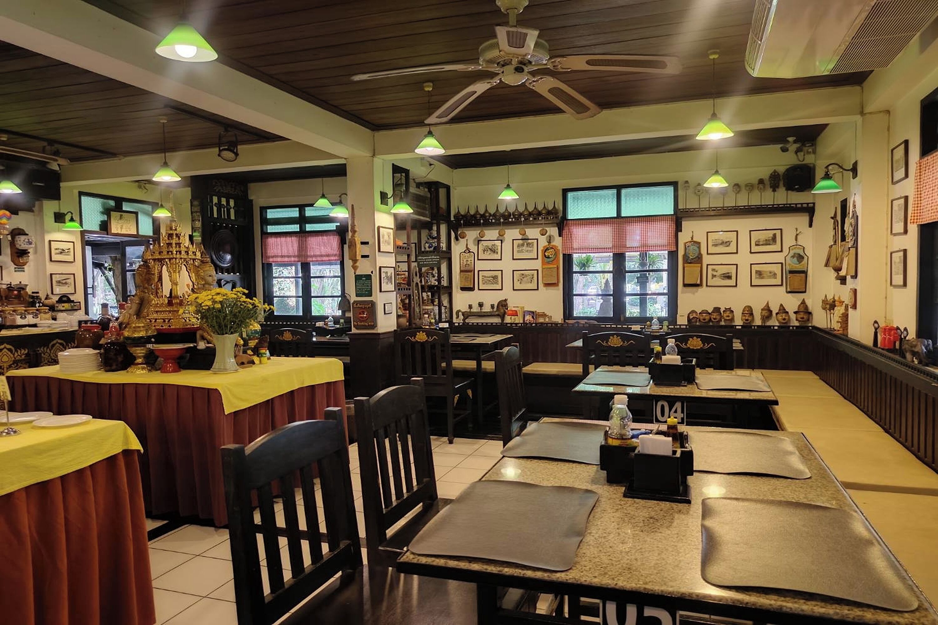 A restaurant with multiple tables, chairs, and a ceiling fan.