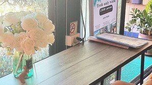Una mesa con una laptop, un florero y un letrero que indica un paseo exclusivo para caminantes, con capacidad para 1500 personas.