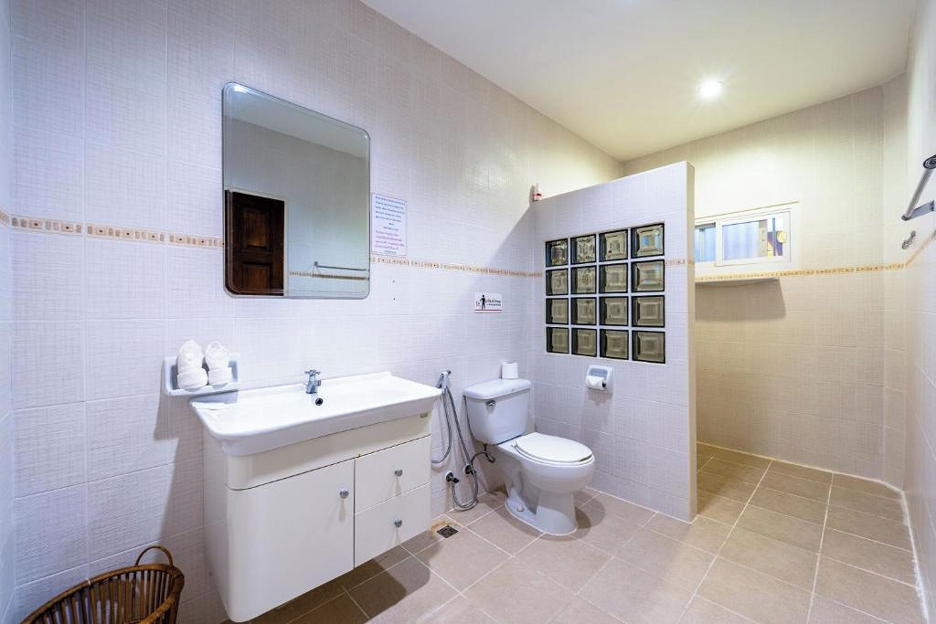 A bathroom with a white sink, mirror, toilet, and a wall-mounted medicine cabinet.