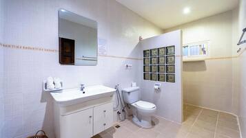 A bathroom with a white sink, mirror, toilet, and a wall-mounted medicine cabinet.