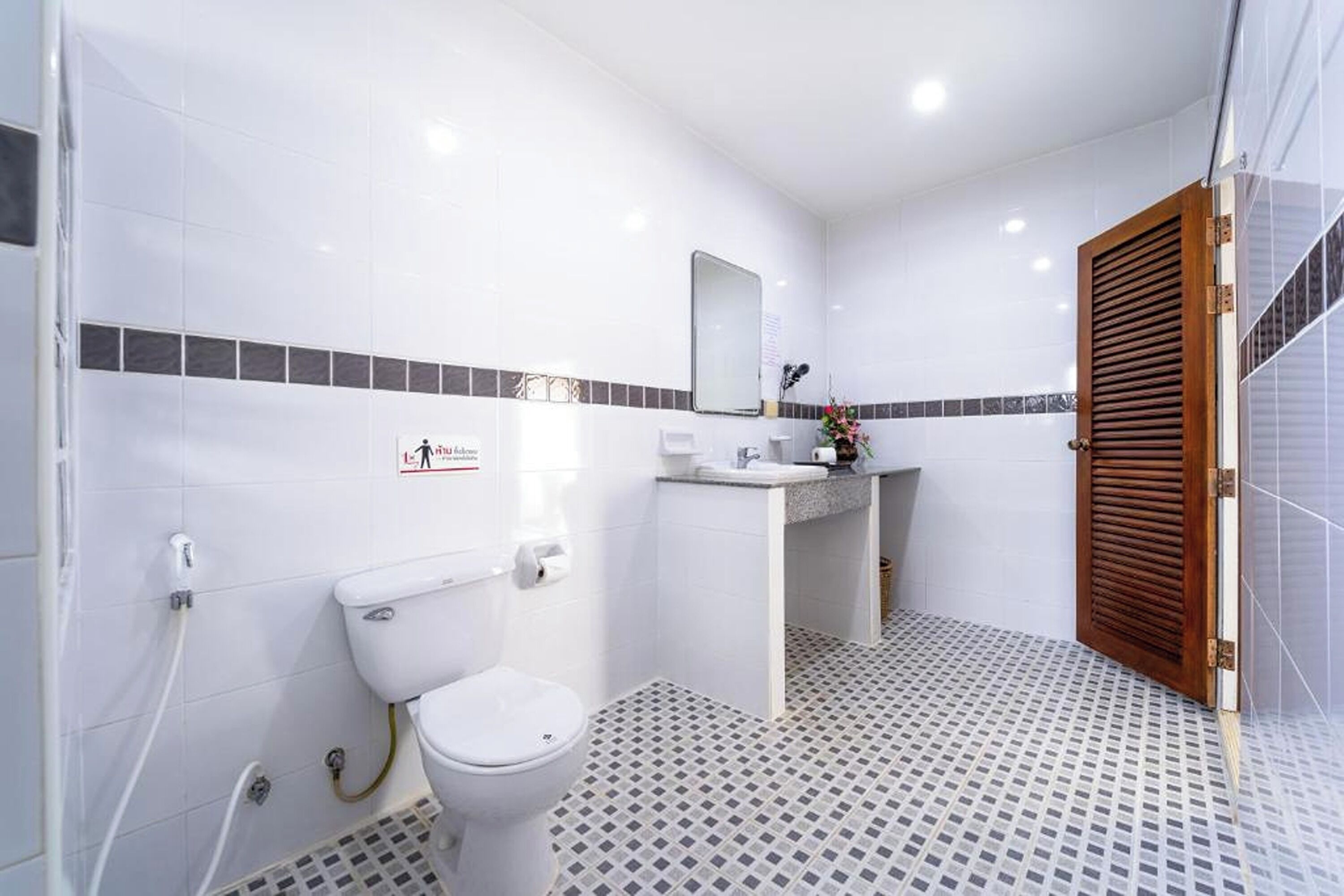 Een badkamer met toilet, wastafel, spiegel en douche.