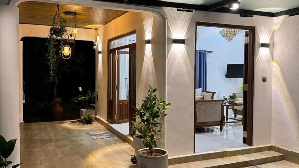 A modern interior with a wooden floor, a seating area, and a potted plant. - Cealora Resort (Dambulla)