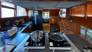 Cocina compacta con estufa, microondas y pileta.