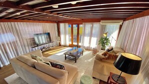 Un salón amplio con sofá, mesa de centro y televisor.