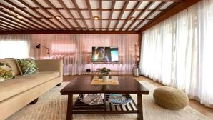 Una sala de estar con un sofá, una mesa de centro y una televisión.