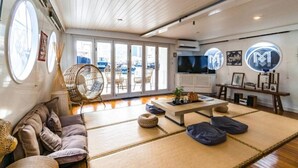 Una habitación con un sofá, una silla colgante, una mesa de centro y un televisor.
