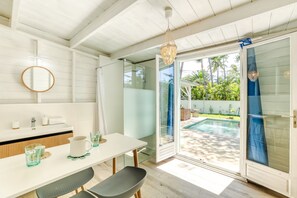 A modern bathroom with a shower, a sink with toiletries, and a glass door leading to a pool area. - Fleur de Sel - Villa 4 Piscine L'etang-sale (La Celle-sous-Gouzon)