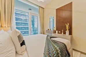 A hotel room with a bed, a window with curtains, a wooden panel wall, and a mirror. - 2-BR Missoni Luxury with Stunning Lake View (Dubai)