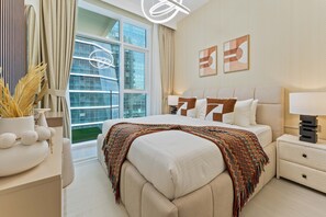 A modern hotel bedroom with a large bed, a nightstand, a bedside table, a window with curtains, and a view of a building. - 2-BR Missoni Luxury with Stunning Lake View (Dubai)