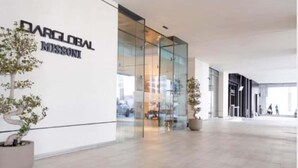 A modern building with a glass facade and a sign reading 'DARGLOBAL MISSION'.