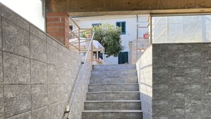 Una escalera con paredes de piedra y techo de vigas de madera.