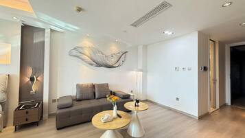 A modern living room with a sofa, two side tables, and a decorative wall piece.