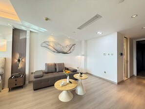 Ein modernes Wohnzimmer mit einer Couch, zwei Beistelltischen und einer Wanddekoration.