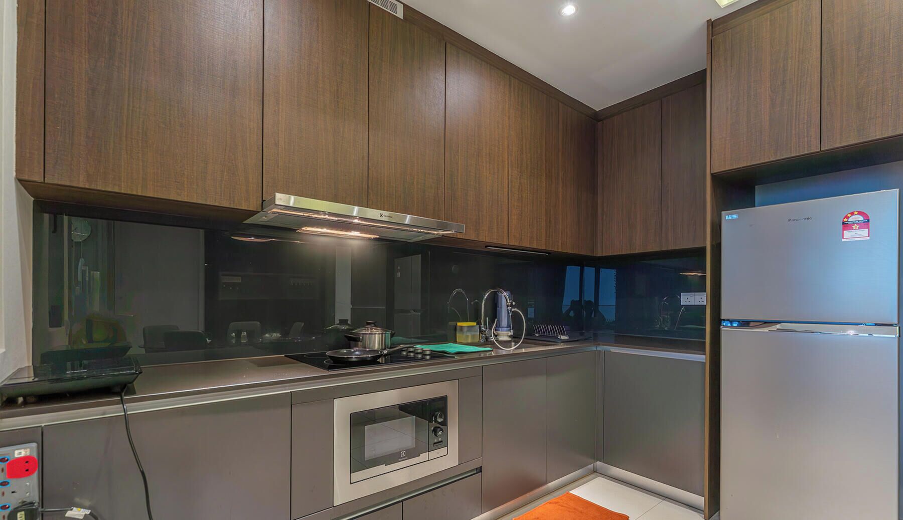 A modern kitchen with wooden cabinets, stainless steel appliances, and a built-in oven.