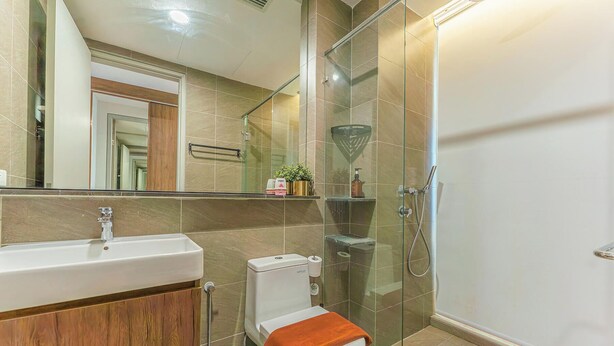 A bathroom with a sink, toilet, and glass-enclosed shower. - Grand Medini Residence by Stayrene  (Iskandar Puteri)