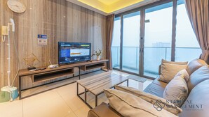 Een moderne woonkamer met een televisie, een bank en een balkon met uitzicht.