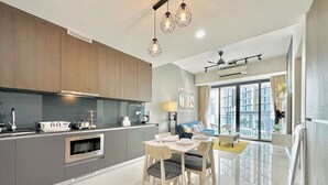 A modern kitchen with a dining area, featuring a large window with a city view. - Grand Medini Residence by Stayrene  (Iskandar Puteri)
