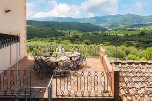 A terrace with a table set for breakfast, overlooking a mountainous landscape. - Period residence located only 20 km from Florence! (Rignano sull'Arno)