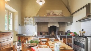 Une cuisine avec une table en bois, un verre à vin et des ustensiles de cuisine.
