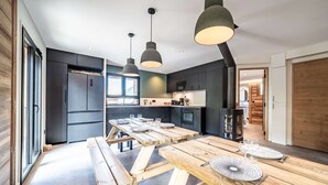 A modern kitchen with dark cabinetry, a central island, and pendant lighting.