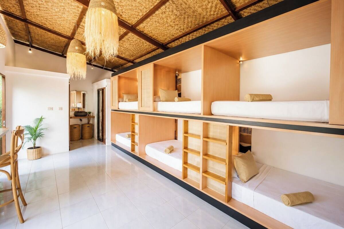 A multi-level room with bunk beds, a woven ceiling, and a hanging light fixture.