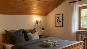 A bedroom with a wooden bed, a nightstand, a wall-mounted lamp, and a window with curtains.