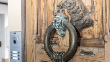 A wooden door with a metal ring handle featuring a lion's head design.