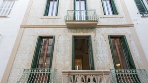 A building facade with ornate architectural details, including decorative moldings and green shutters on windows. - The Residences At Bartomeu 26, Suite Maricel, Spacious Elegance & Comfort (Sitges)