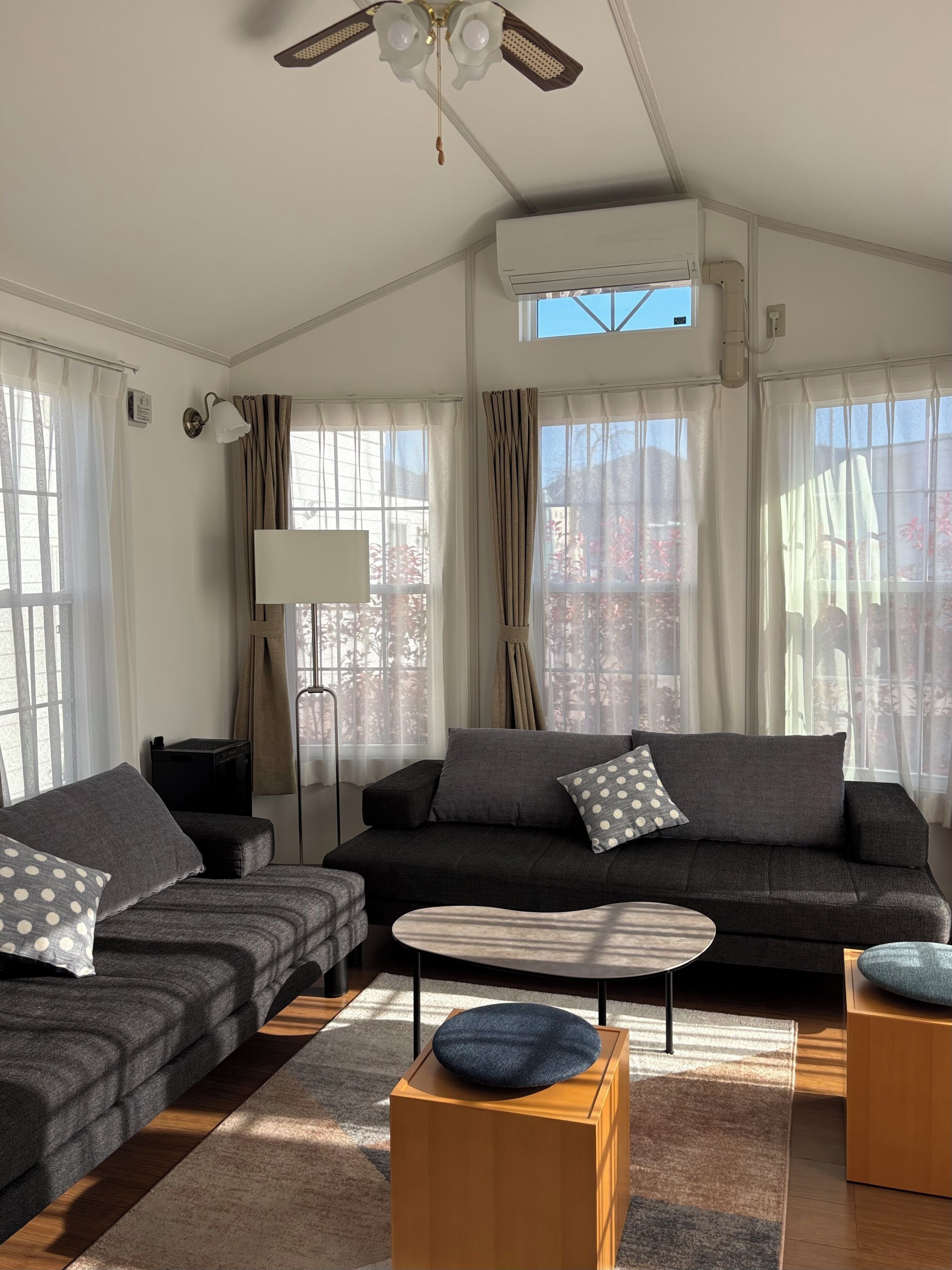 A modern living room with a dark grey sofa, a round coffee table, and a wooden side table.