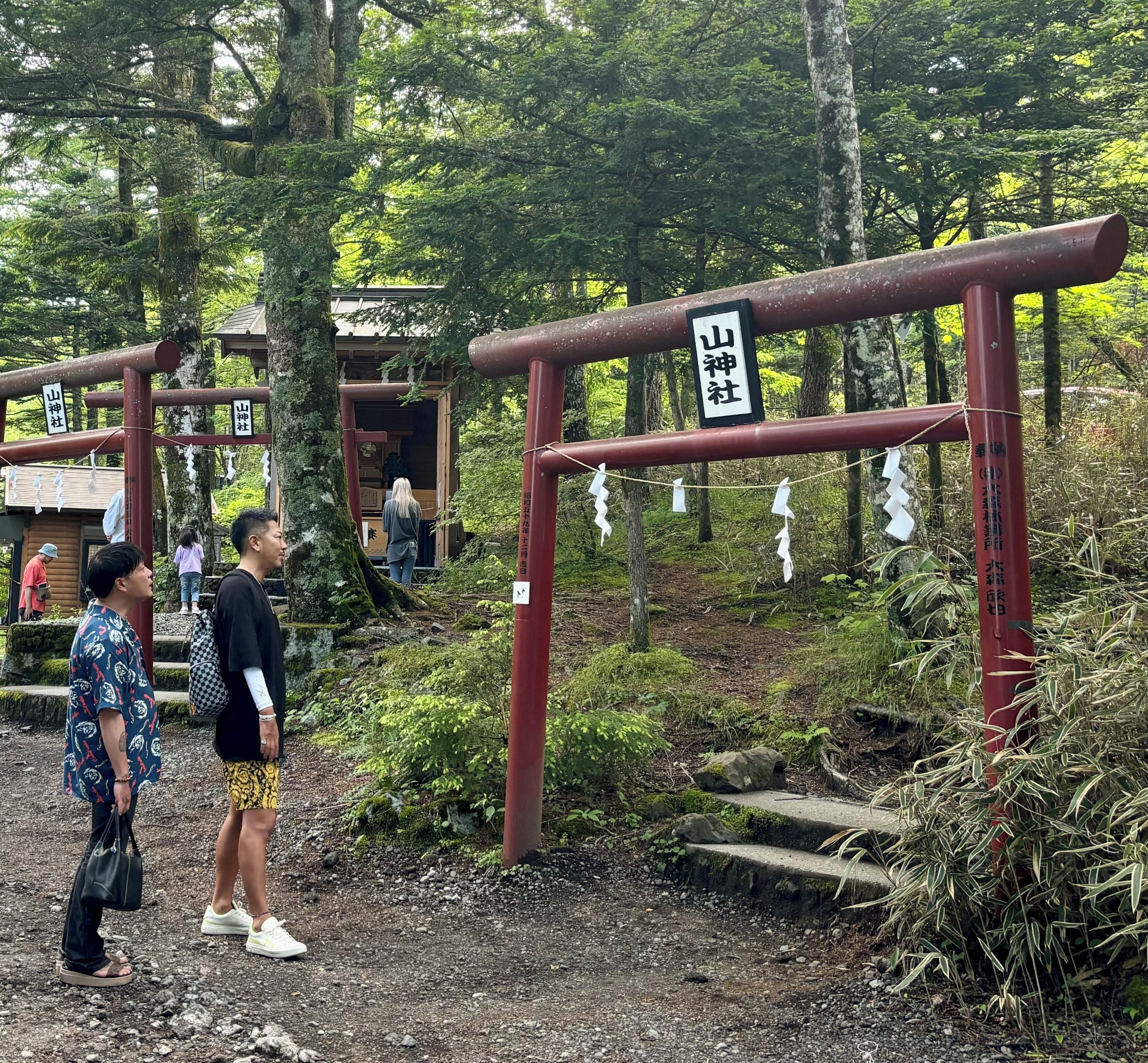 Un torii japonès tradicional amb una estructura de fusta i un rètol.