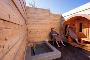 A wooden cabin with a sauna, a small outdoor seating area, and a hot tub. - Inn the Fuji (Fujiyoshida)