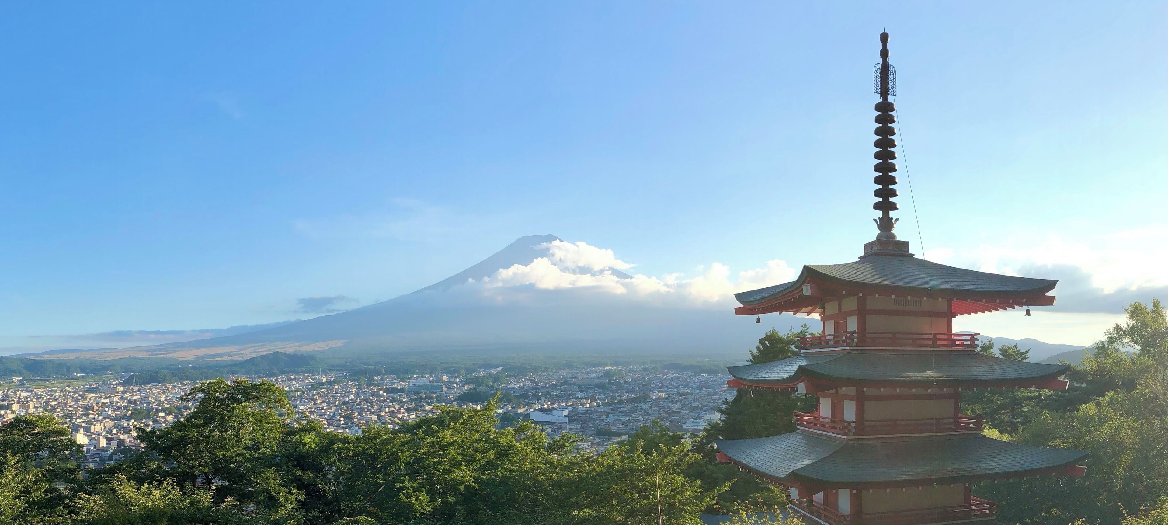 A pagoda with a view of a mountain and a cityscape.