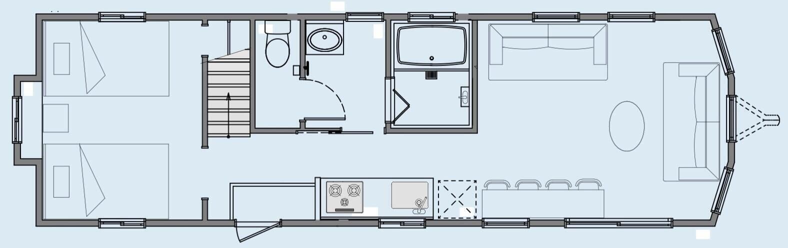 Un plan d’étage d’un hôtel comprenant une cuisine, un coin repas, deux chambres, une salle de bain et un petit espace extérieur aménagé pour s’asseoir.