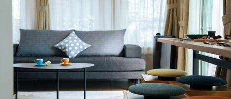 A modern living room with a grey sofa, a round coffee table, and a small side table.