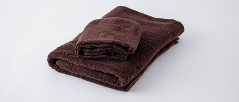 A folded brown towel on a white surface.