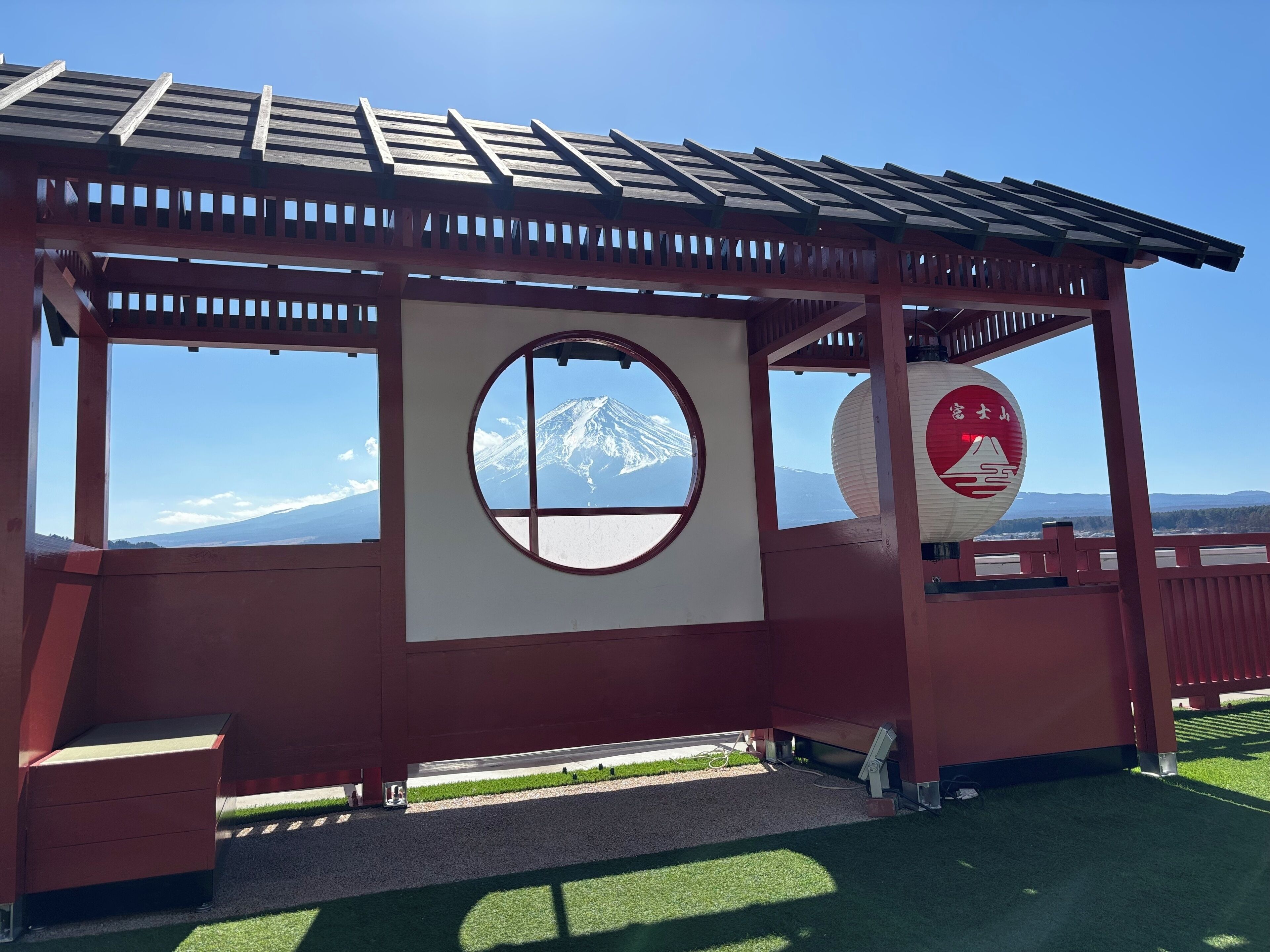 A wooden observation deck with a view of a snow-capped mountain.
